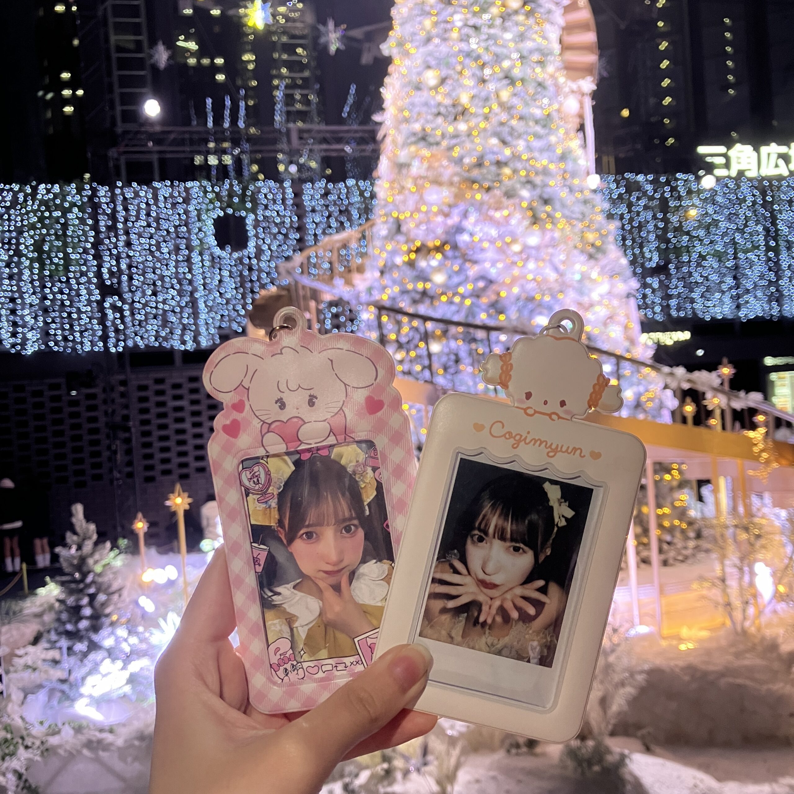 住友ビルのツリー前で推しの写真を持って推し活している様子